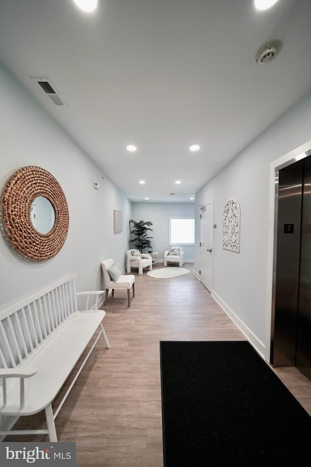 hall featuring light wood-type flooring and elevator