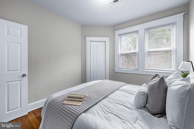 bedroom with a closet and dark hardwood / wood-style flooring