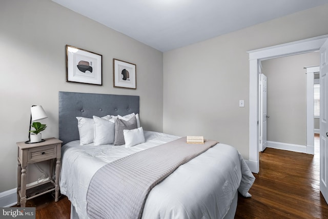 bedroom with dark hardwood / wood-style floors