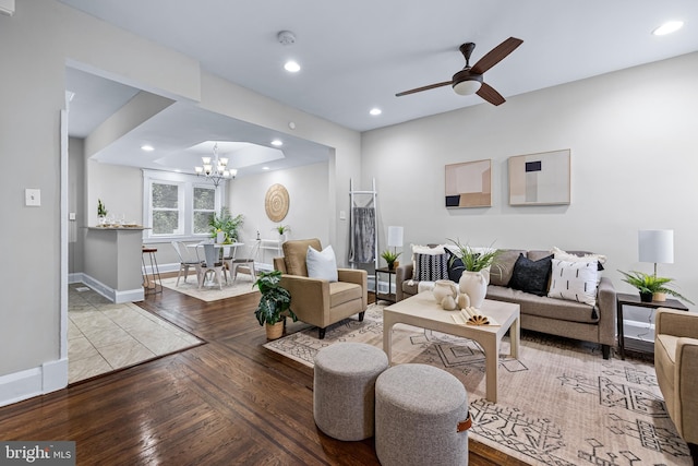 living room featuring light hardwood / wood-style flooring and ceiling fan with notable chandelier