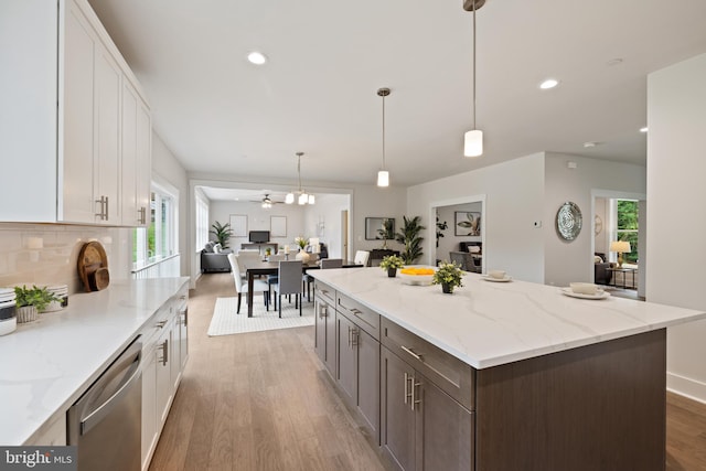 kitchen with white cabinets, hardwood / wood-style flooring, stainless steel dishwasher, and a wealth of natural light