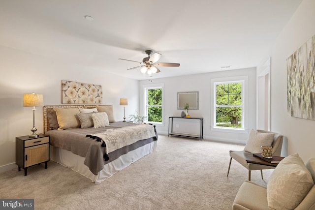 carpeted bedroom with ceiling fan and multiple windows