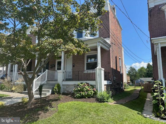 view of front of home with a front yard and covered porch