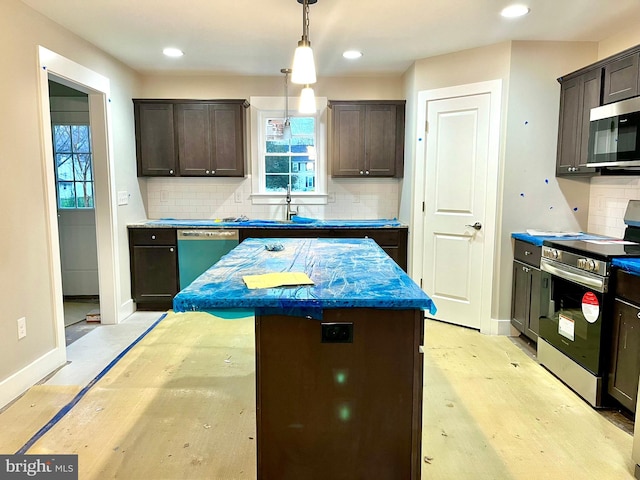 kitchen with backsplash, decorative light fixtures, a kitchen island, dark brown cabinetry, and stainless steel appliances