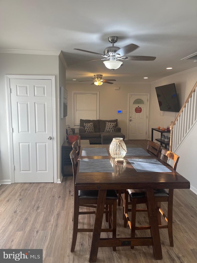 dining room with ornamental molding, wood-type flooring, and ceiling fan