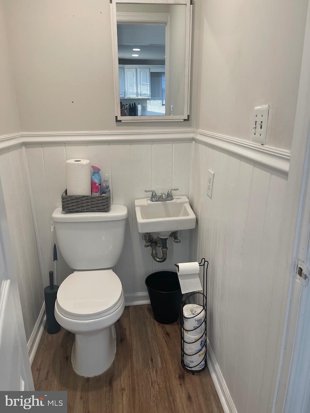 bathroom featuring toilet, sink, and hardwood / wood-style floors