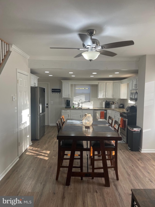 dining room featuring crown molding, dark wood-type flooring, and ceiling fan