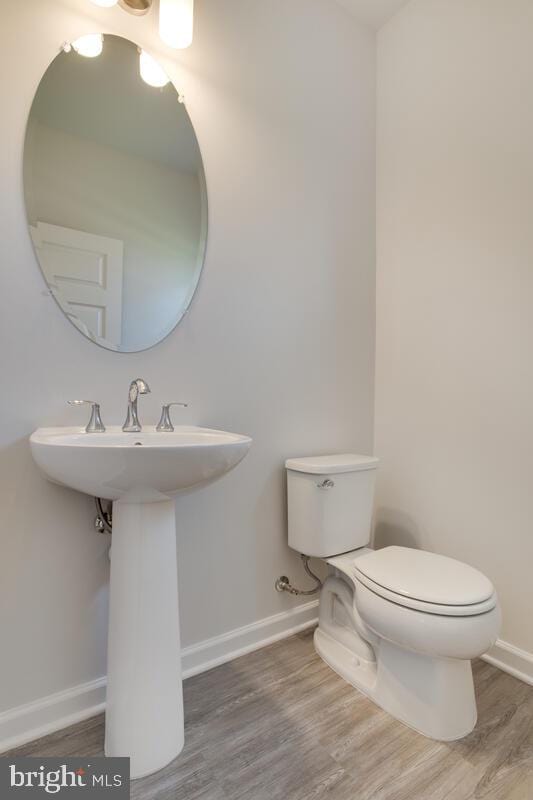 bathroom featuring toilet and wood-type flooring