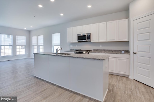 kitchen with stainless steel appliances, light hardwood / wood-style floors, sink, and white cabinetry