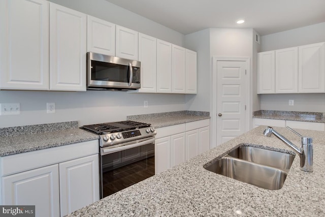 kitchen featuring stainless steel appliances, white cabinets, and sink