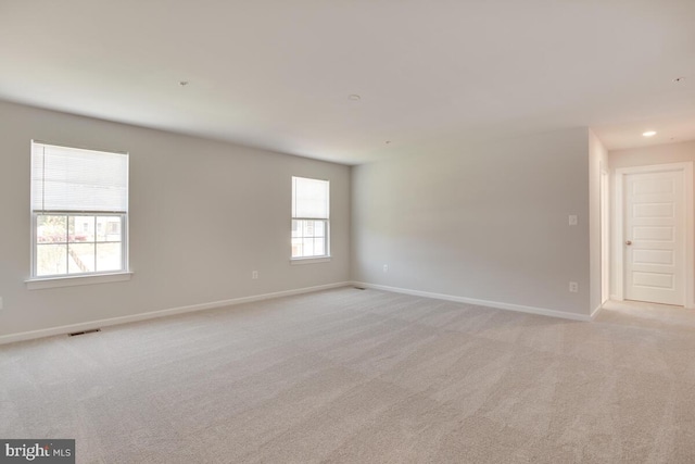 spare room with light carpet and a wealth of natural light