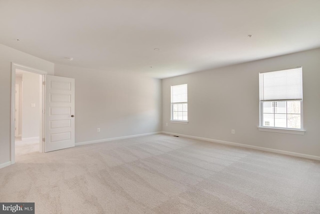 unfurnished room with light carpet and plenty of natural light