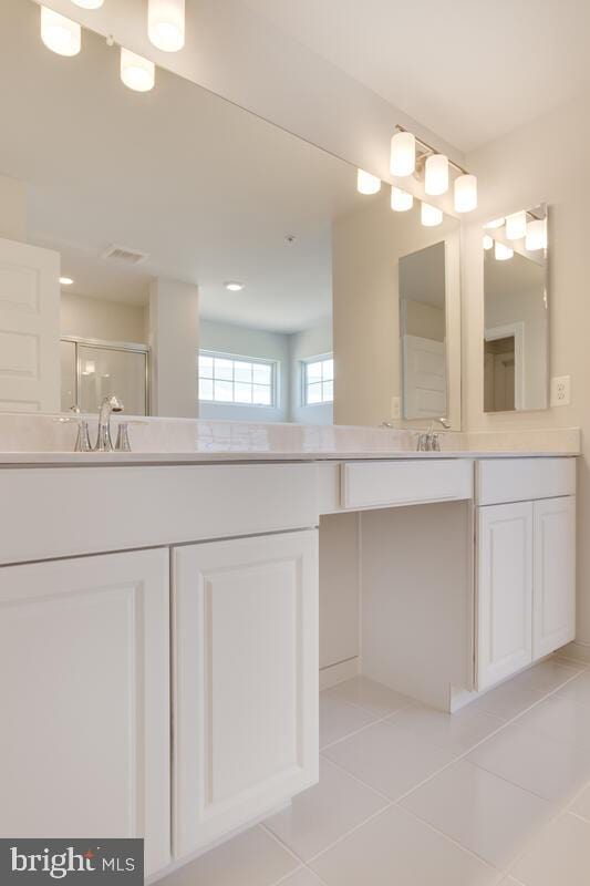 bathroom with tile patterned floors, vanity, and an enclosed shower