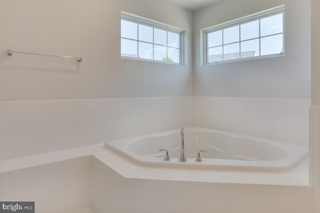 bathroom featuring tiled tub