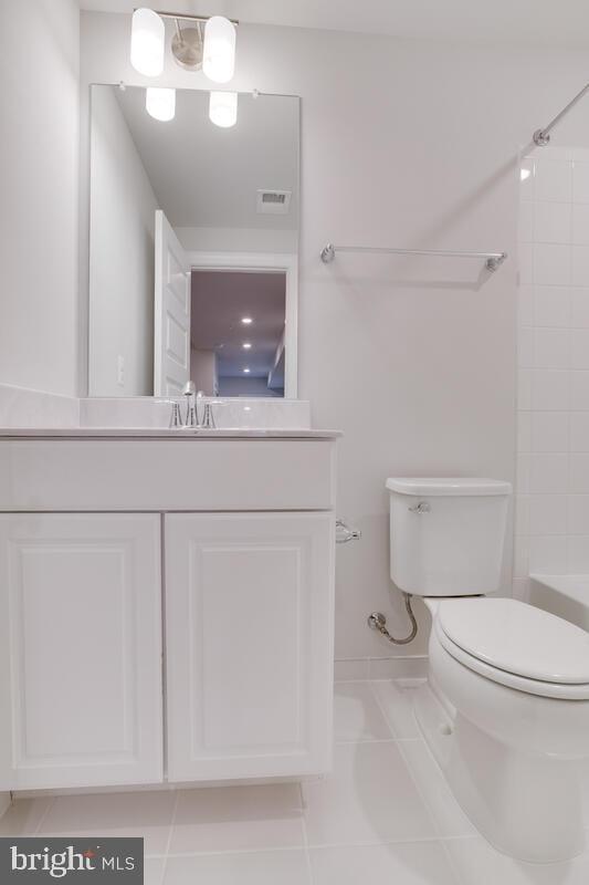 full bathroom featuring vanity, tile patterned flooring, toilet, and tiled shower / bath