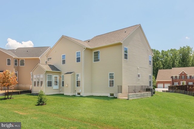 back of property with a yard and central AC