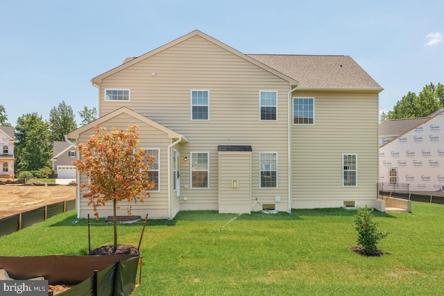 back of house featuring a garage and a yard