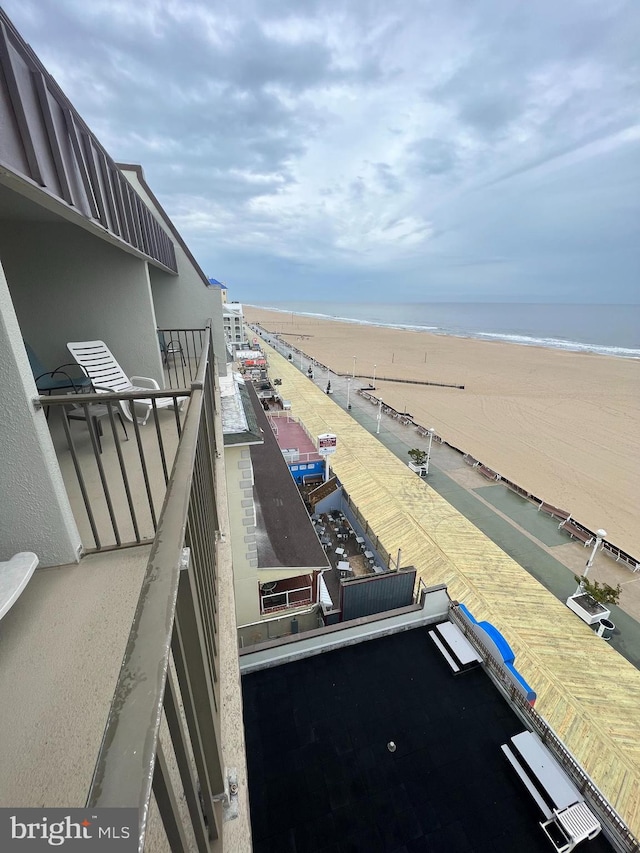 exterior space featuring a beach view, a balcony, and a water view