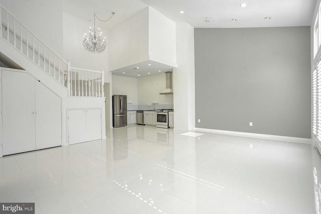 unfurnished living room featuring a chandelier, a high ceiling, and light tile patterned floors