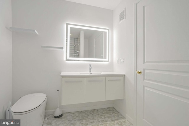 bathroom featuring toilet, vanity, and tile patterned floors