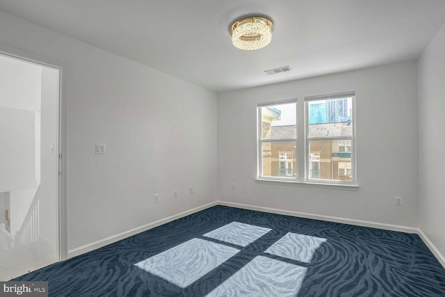 spare room with dark carpet