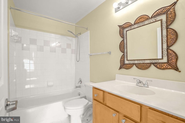 full bathroom featuring tiled shower / bath, vanity, toilet, and tile patterned flooring