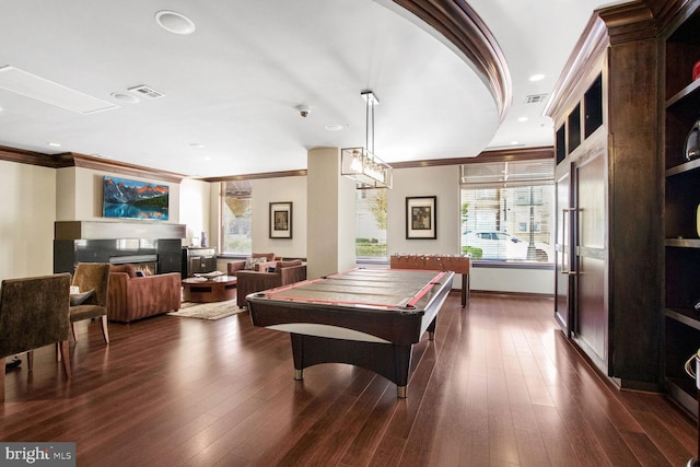 recreation room featuring dark hardwood / wood-style flooring, ornamental molding, and plenty of natural light