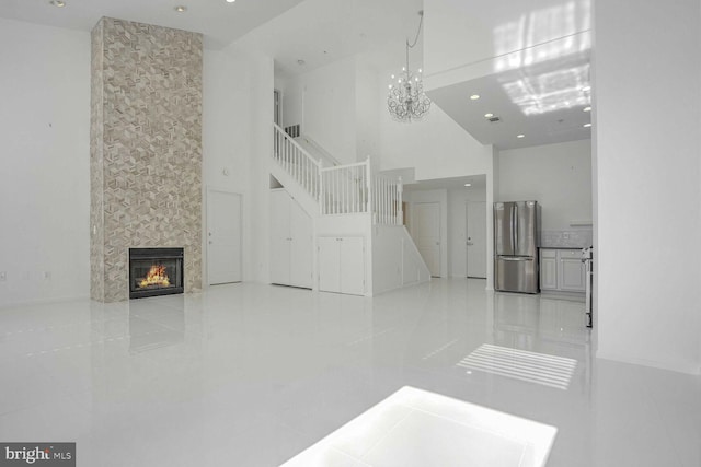 tiled living room featuring a towering ceiling and a fireplace