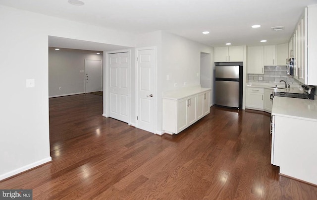 kitchen with stainless steel appliances, tasteful backsplash, dark hardwood / wood-style floors, and white cabinets