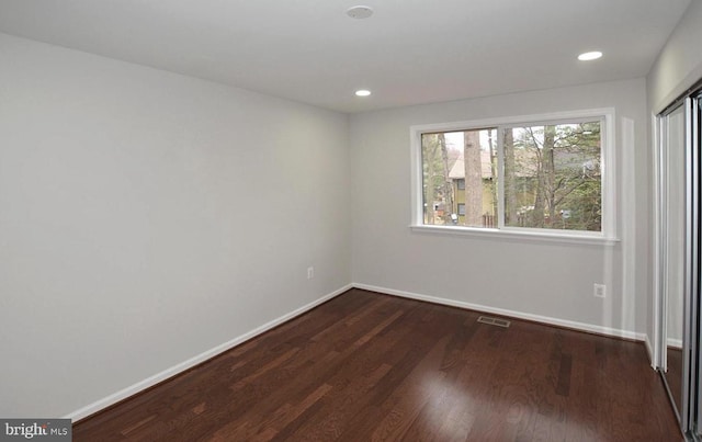 unfurnished room featuring dark wood-type flooring