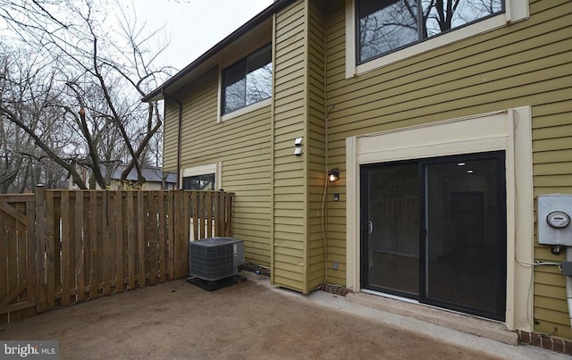 view of exterior entry with a patio area and cooling unit