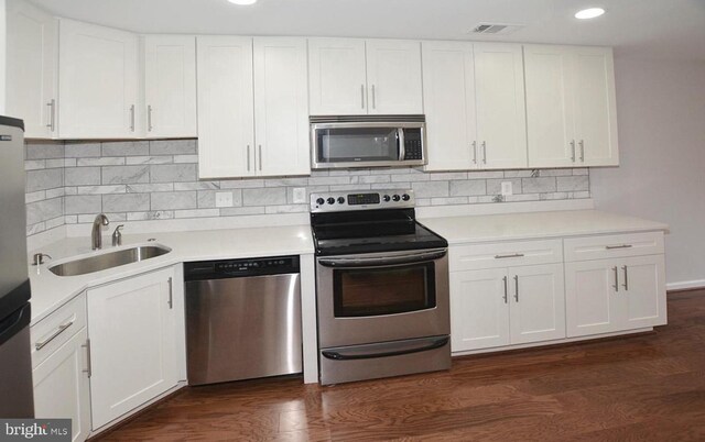 kitchen with white cabinets, tasteful backsplash, dark hardwood / wood-style floors, sink, and stainless steel appliances