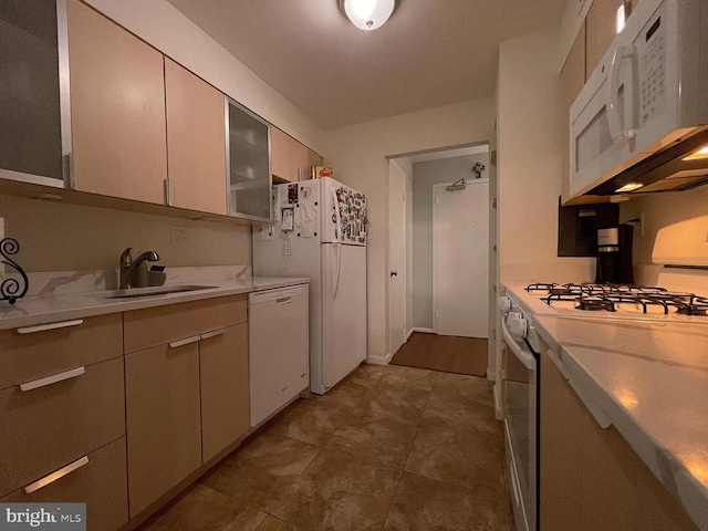 kitchen featuring sink, dark tile patterned flooring, and white appliances