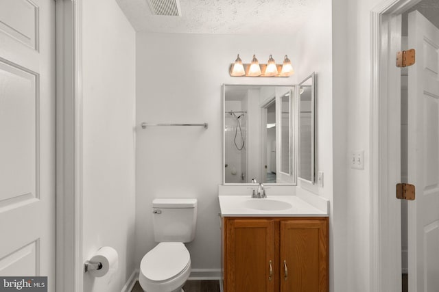 bathroom featuring vanity, a textured ceiling, and toilet