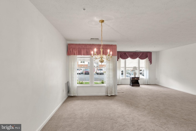 unfurnished dining area featuring a notable chandelier, a textured ceiling, and carpet floors