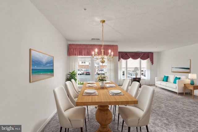 dining area with carpet flooring, a notable chandelier, a textured ceiling, and plenty of natural light