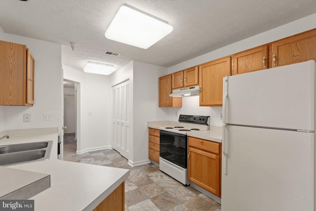 kitchen featuring white appliances, a textured ceiling, and sink