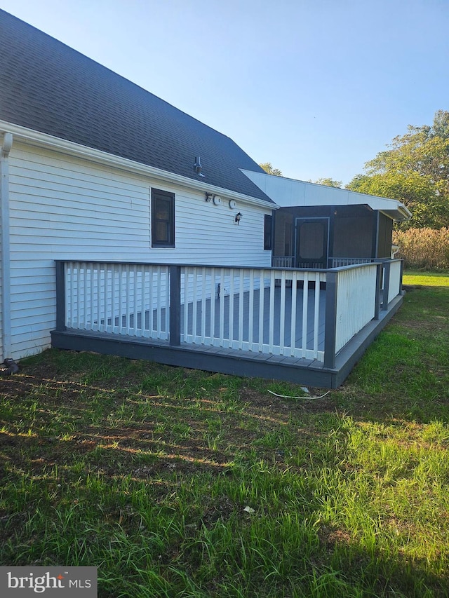 rear view of house featuring a lawn and a wooden deck