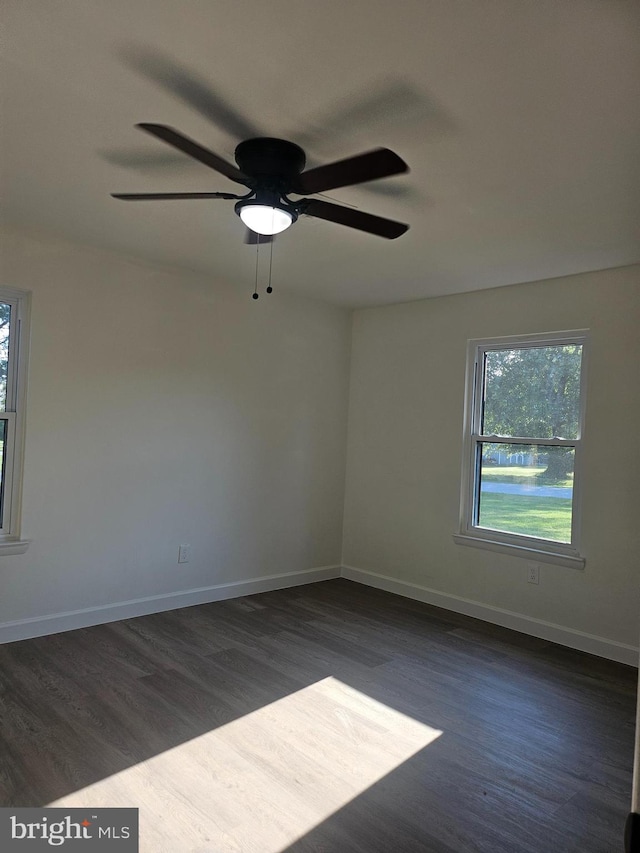 empty room featuring ceiling fan and dark wood-type flooring