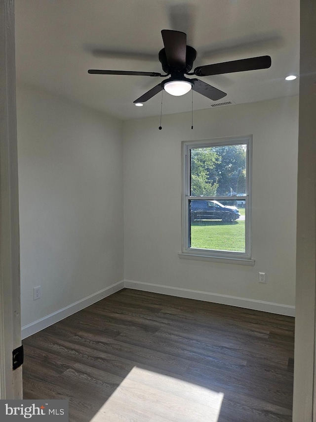 unfurnished room with ceiling fan and dark wood-type flooring