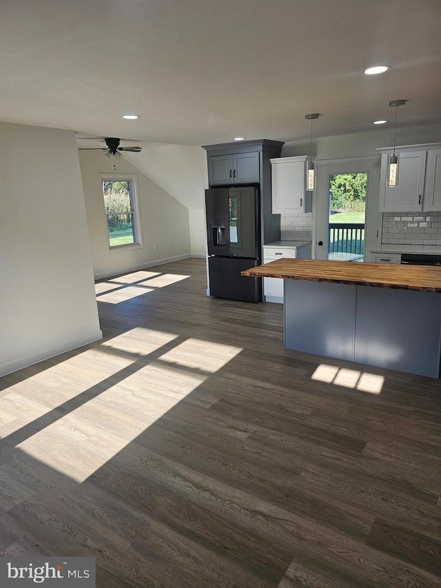 kitchen featuring wooden counters, dark hardwood / wood-style flooring, tasteful backsplash, black refrigerator with ice dispenser, and pendant lighting