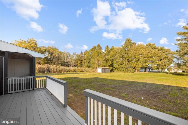 wooden terrace featuring a storage shed and a lawn