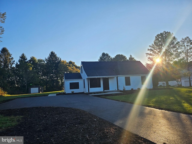 view of front of home with a front yard and an outbuilding