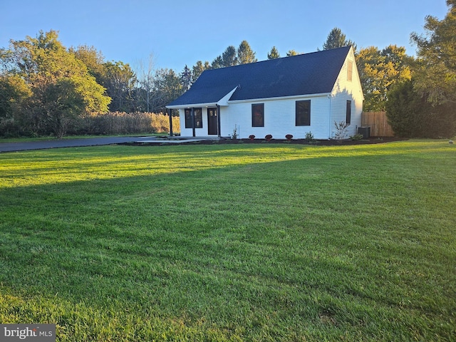 view of front of property with central air condition unit and a front yard