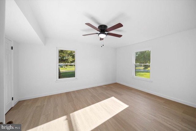 empty room featuring ceiling fan, plenty of natural light, and light hardwood / wood-style floors