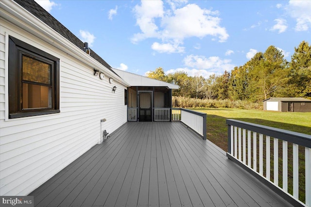 wooden terrace featuring a yard and an outbuilding