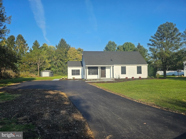 ranch-style house featuring a front lawn, an outdoor structure, and a garage