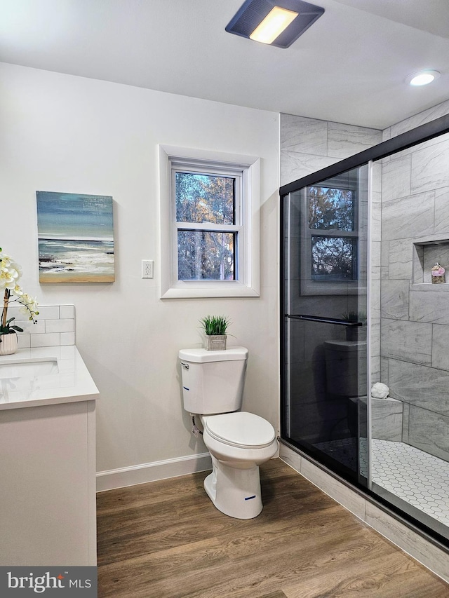 bathroom with vanity, hardwood / wood-style flooring, toilet, and an enclosed shower