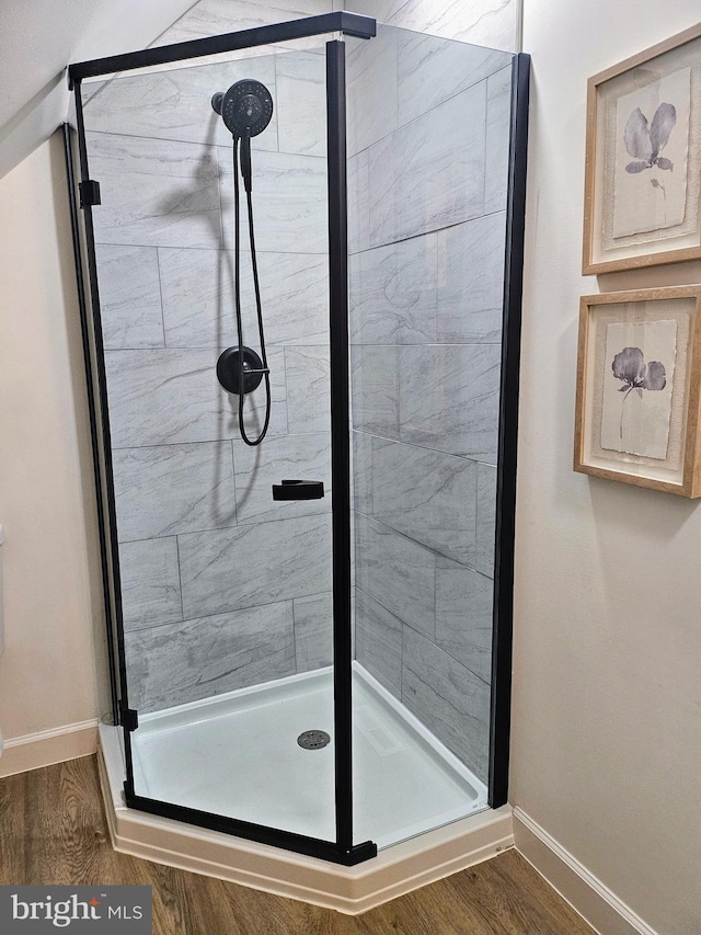 bathroom with an enclosed shower and wood-type flooring