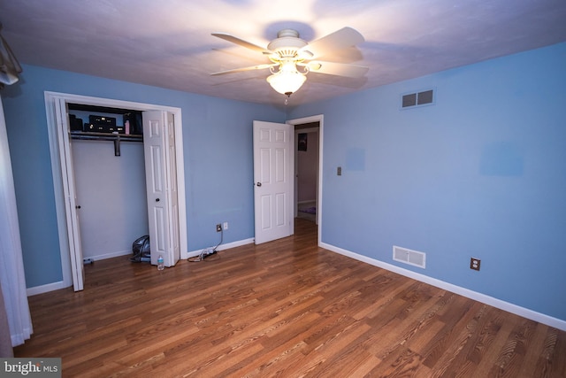 unfurnished bedroom with ceiling fan, a closet, and dark hardwood / wood-style floors